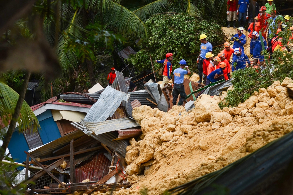Rescuers search for survivors at the landslide site in Naga City, on the popular tourist island of Cebu, on Thursday. — AFP