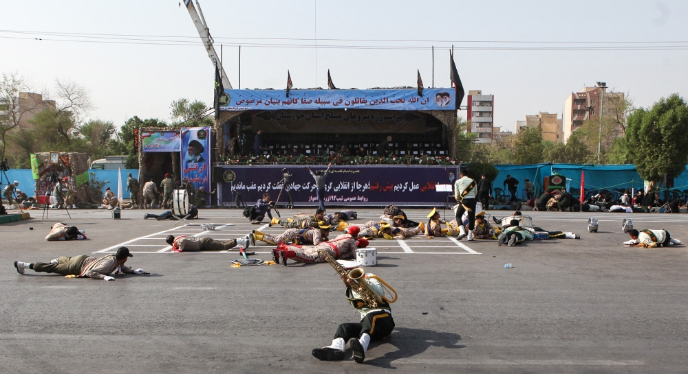 This picture taken on Saturday in the southwestern Iranian city of Ahvaz shows injured soldiers lying on the ground at the scene of an attack on a military parade that was marking the anniversary of the outbreak of its devastating 1980-1988 war with Iraq. — AFP