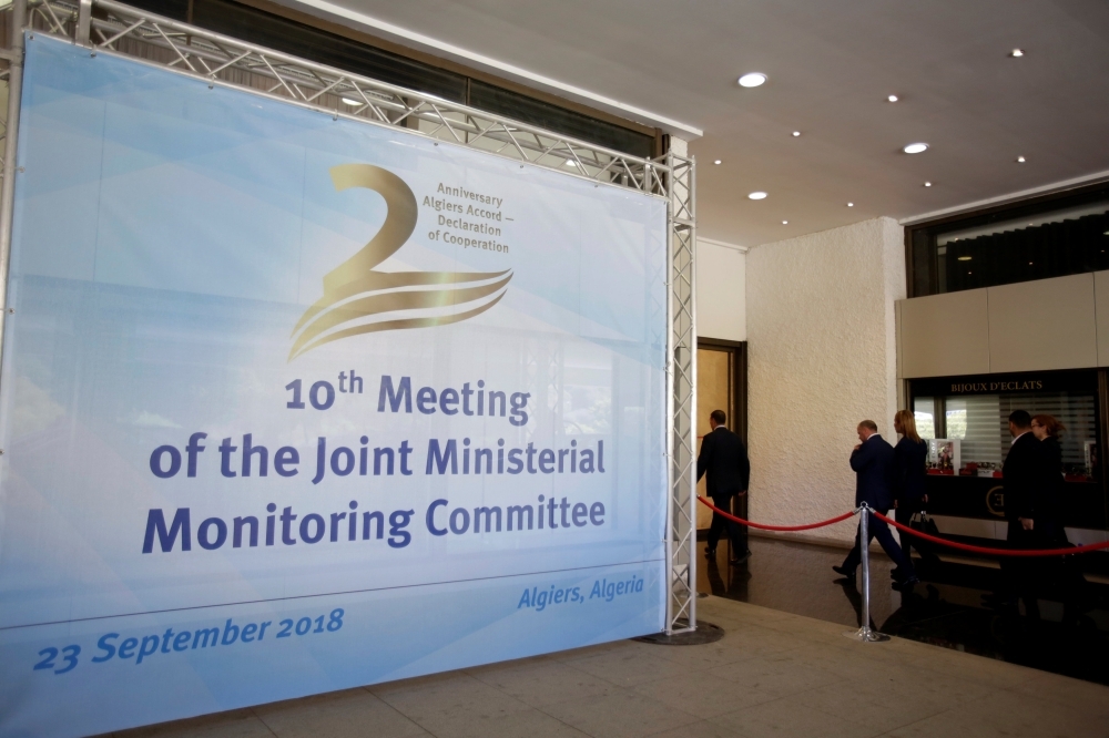 


People walk past a billboard for the 10th meeting of the OPEC Joint Ministerial Monitoring Committee in Algiers, Algeria. — Reuters
