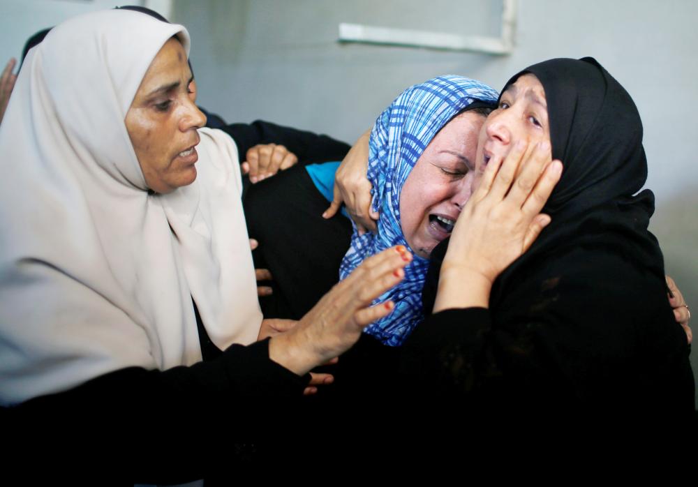 


Relatives of Palestinian Imad Ishtawi, who was killed on the Israel-Gaza border fence, mourn during his funeral in Gaza City, Monday. — Reuters