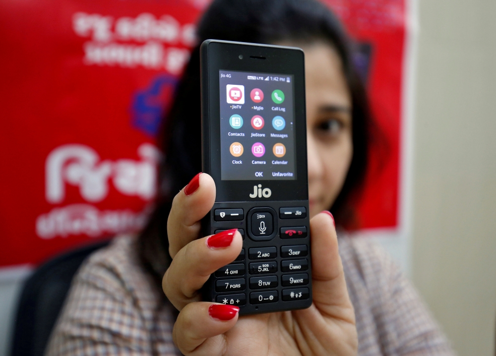 A sales person displays JioPhone as she poses for a photograph at a store of Reliance Industries Jio telecoms unit, on the outskirts of Ahmedabad, India, in this Sept. 26, 2017 file photo. — Reuters