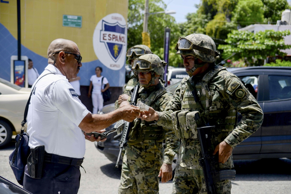 Mexican Navy members and Federal policemen take part in an operation in Acapulco, state of Guerrero, Mexico, on Tuesday. — AFP