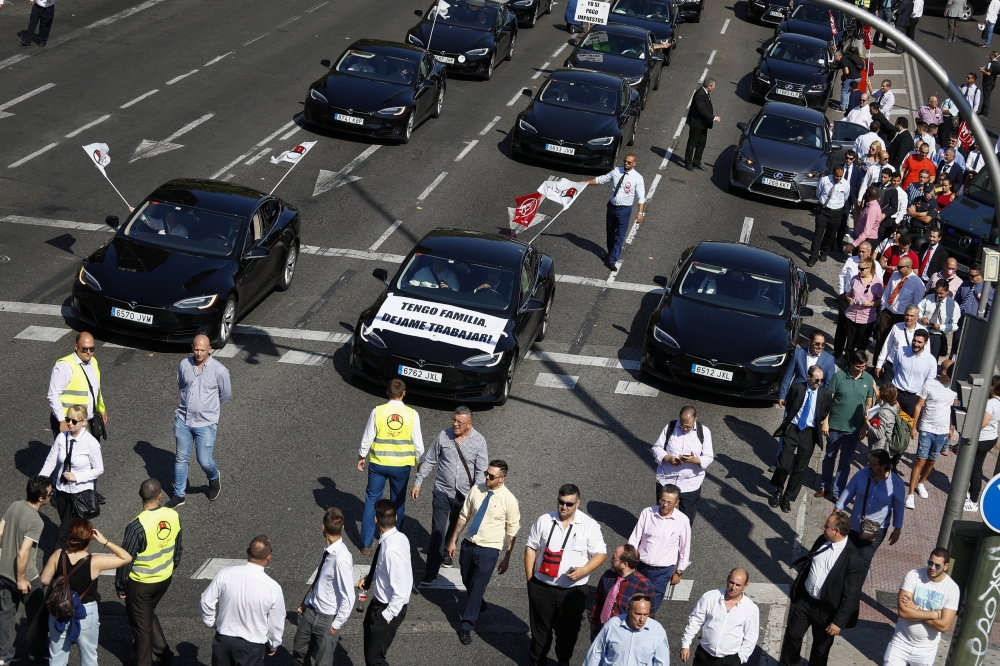 Drivers from shared-ride services Uber and Cabify attend a demonstration in Madrid as part of a strike to protest a law that aims to regulate shared-ride services in Madrid, Spain, Thursday. — Reuters