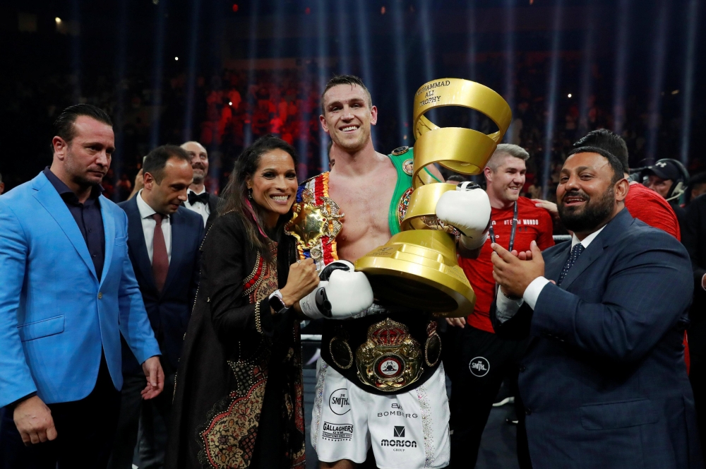 


Holding Mohammed Ali Trophy, Callum Smith poses with boxing legend’s daughter Rasheda Ali, “Prince” Naseem Hamed and other officials.