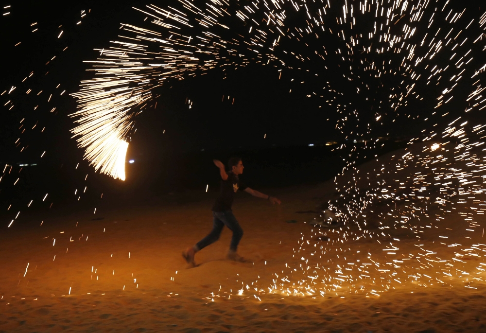 Palestinians gather during a protest calling for lifting the Israeli blockade on Gaza, on a beach near the maritime border with Israel, in the northern Gaza Strip, Monday. — Reuters