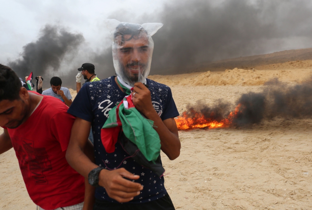 Palestinians gather during a protest calling for lifting the Israeli blockade on Gaza, on a beach near the maritime border with Israel, in the northern Gaza Strip, Monday. — Reuters