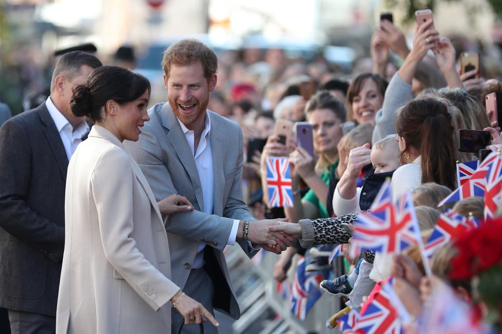 Britain's Prince Harry, and Meghan, Duchess of Sussex, greet well-wishers as they arrive for a visit to Edes House, in Chichester, Britain, on Wednesday. — Reuters
