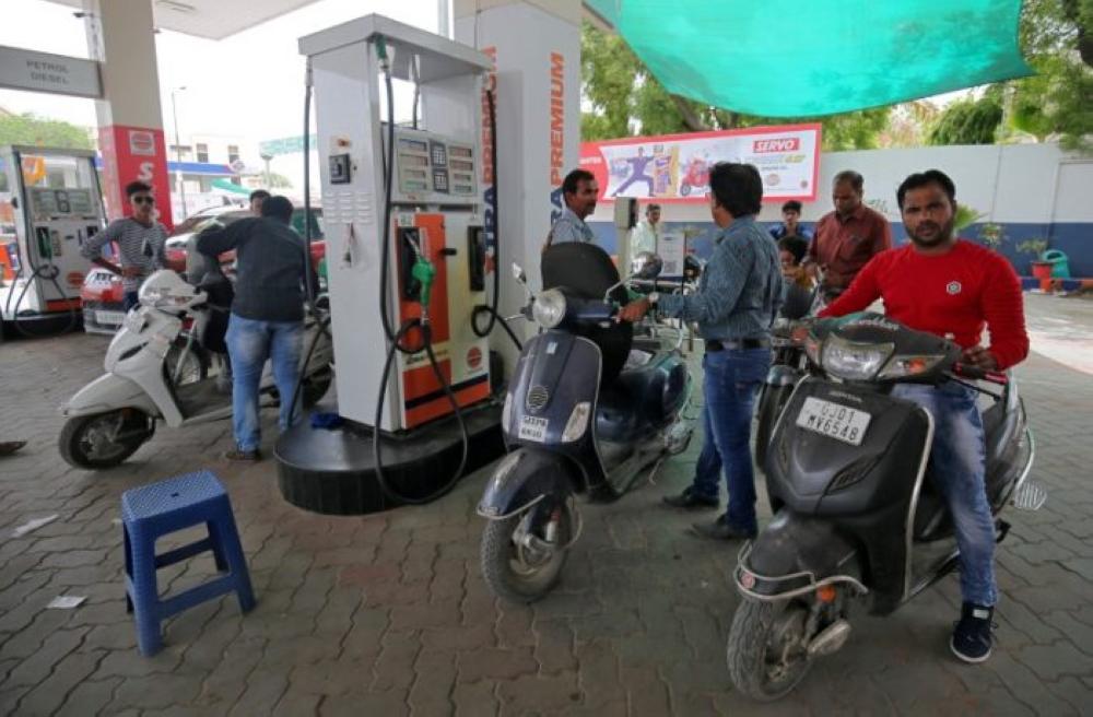 Indians wait to fill petrol at a filling station as India Finance Minister Arun Jaitley announced cut in the retail prices of gasoline and diesel fuel by 2.50 rupees ($0.034) per liter on Thursday.