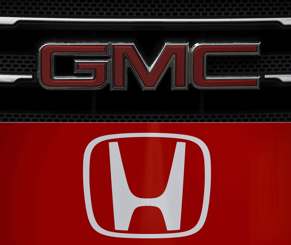 This combination of file pictures created shows the GMC logo displayed on a truck in Colma, California and a photo of the logo of Japanese automobile manufacturer Honda seen at the Autodromo Nazionale circuit in Monza. General Motors and Honda have joined forces with the tech firm Cruise to develop autonomous vehicles as the race to market self-driving cars continues, the companies announced on Wednesday. — AFP