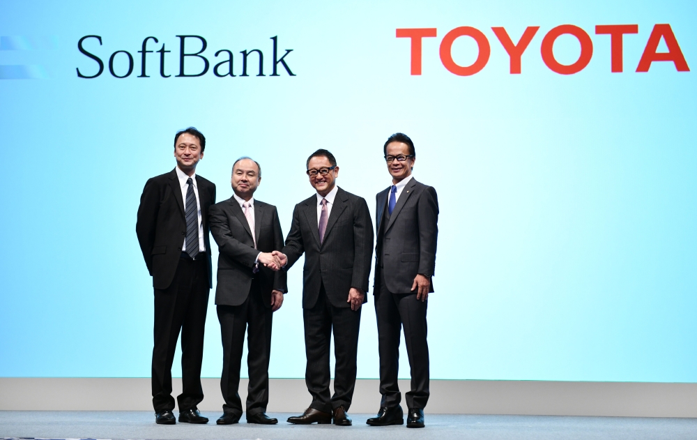 SoftBank Group head Masayoshi Son (2nd L) and Toyota Motor president Akio Toyoda (2nd R) shake hands as SoftBank representative director and chief technology officer Junichi Miyakawa (L) and Toyota Motor executive vice president Shigeki Tomoyama (R) stand alongside during their joint press conference in Tokyo on Thursday. Japanese car giant Toyota and conglomerate Softbank announced a tie-up to develop self-driving vehicles, the latest massive tie-up as the global race to get autonomous cars on the road accelerates. — AFP