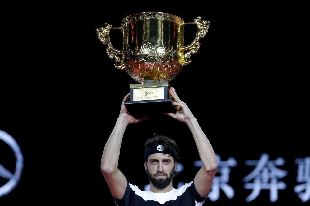Nikoloz Basilashvili of Georgia holds aloft the China Open Trophy after beating Juan Martin del Potro of Argentina in the final at National Tennis Center in Beijing Sunday. — Reuters