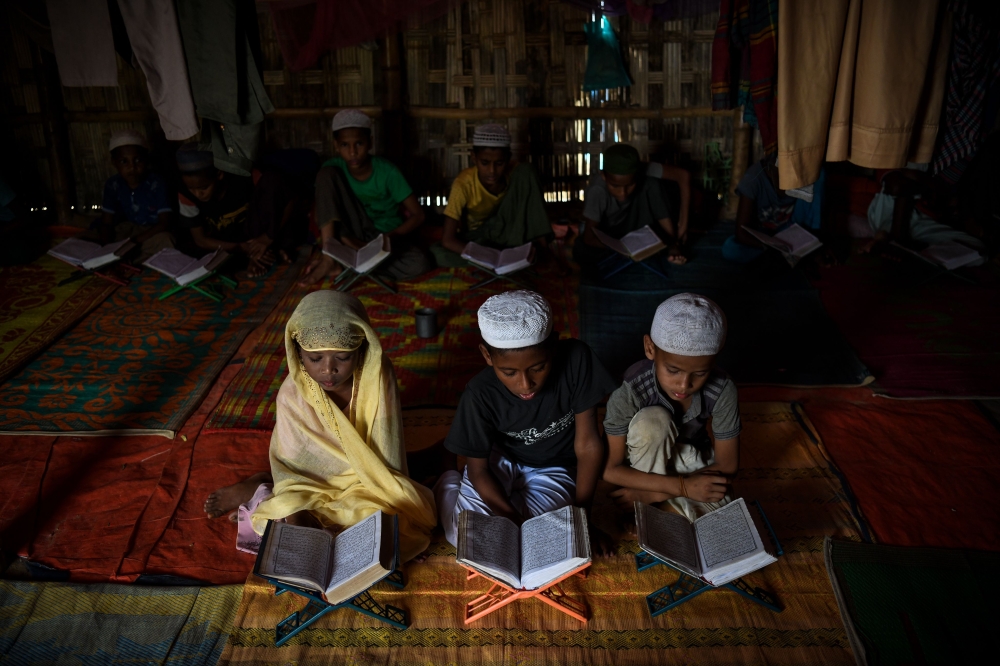 Saleema Khanam, left, 8, studies inside a makeshift madrasa (Islamic seminary) with other boys in Kutupalong camp in Ukhia near Cox’s Bazar in this Aug.12, 2018 file photo. — AFP