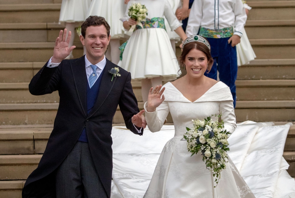 Britain’s Princess Eugenie of York, right, and her husband Jack Brooksbank wave as they emerge from the West Door of St. George’s Chapel, Windsor Castle, in Windsor, on Friday after their wedding ceremony. — AFP