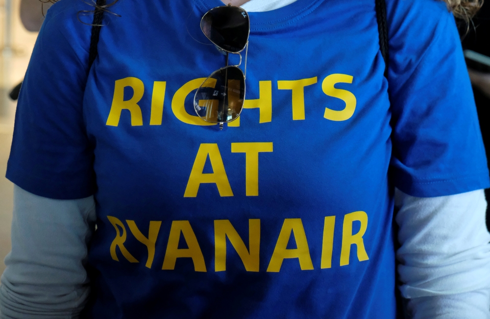 File photo shows a Ryanair worker takes part in a protest inside the departure hall during a strike by Ryanair workers of several European countries, at the airport in Valencia, Spain. — Reuters
