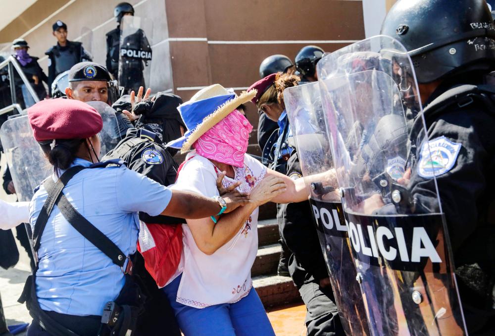 


A Nicaraguan woman is arrested by riot police during a protest against the government of President Daniel Ortega in Managua on Sunday. — AFP