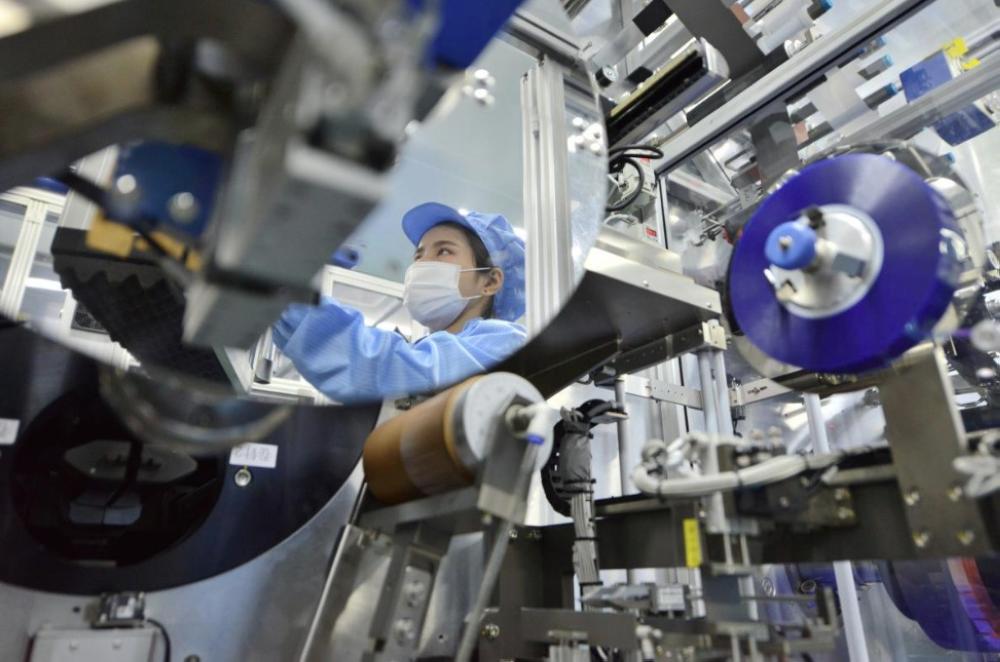 The reflection of a worker is seen at the production line of lithium-ion batteries for electric vehicles (EV) at a factory in Huzhou, Zhejiang province, China. — Reuters