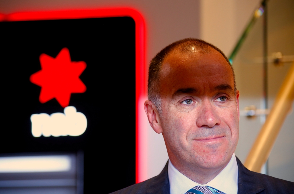 National Australia Bank (NAB) CEO Andrew Thorburn poses for photographs in front of automatic tellar machines (ATMs) during an official event at a branch in central Sydney, Australia, in this file photo. — Reuters