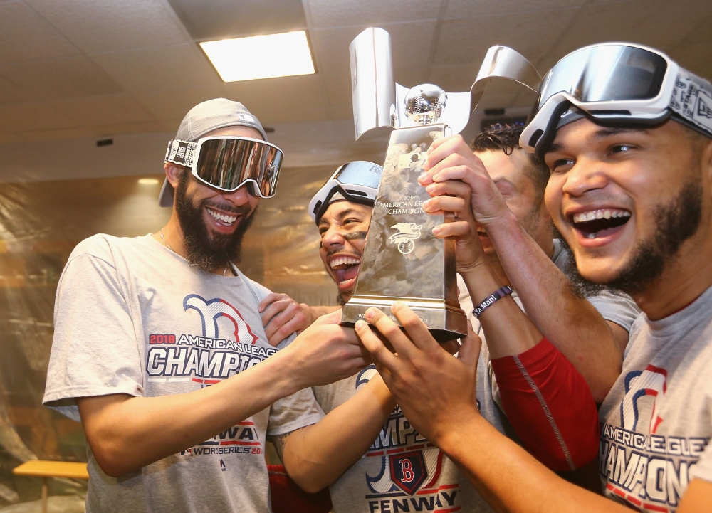 (L-R) David Price No. 24, Mookie Betts No. 50, and Eduardo Rodriguez No. 57 of the Boston Red Sox celebrate with the William Harridge Trophy in the clubhouse after defeating the Houston Astros 4-1 in Game Five of the American League Championship Series to advance to the 2018 World Series at Minute Maid Park on Thursday in Houston, Texas. — AFP
== FOR NEWSPAPERS, INTERNET, TELCOS & TELEVISION USE ONLY ==