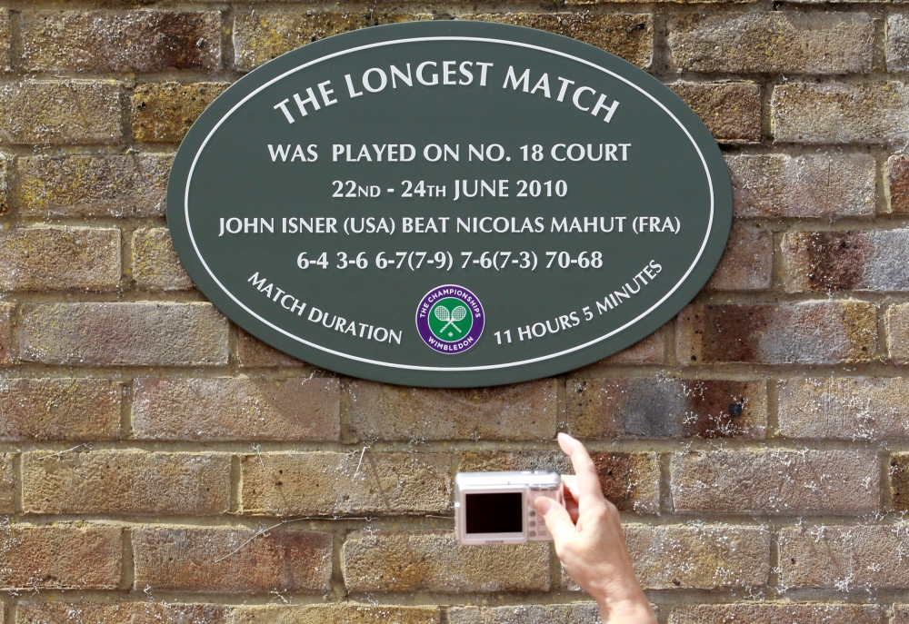 File photo shows a spectator photographing a plaque attached to the wall of No. 18 court after the match in 2010 that lasted more than 11 hours, between John Isner of the US and Nicolas Mahut of France, at the Wimbledon tennis championships in London on June 21, 2011. — Reuters
