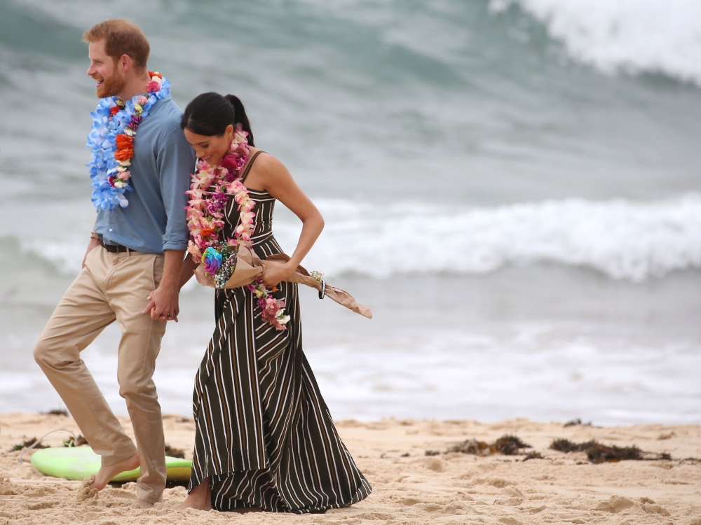 Britain’s Prince Harry walks with his wife Meghan, Duchess of Sussex as they meet the local community at Bondi Beach in Sydney on Friday. — AFP