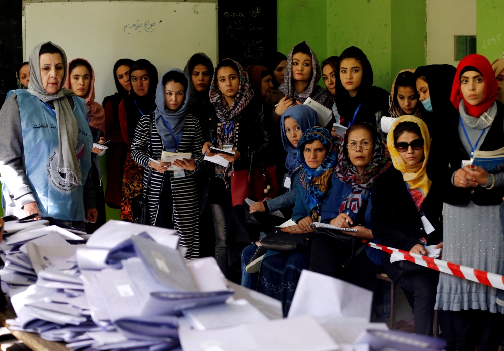 Election observers watch counting of ballots during parliamentary elections at a polling station in Kabul, Sunday. — Reuters