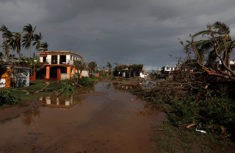 A general view shows a flooded street and fallen trees in the town of Teacapan near the southern tip of Sinaloa state after Hurricane Willa hit Mexico on Wednesday. — Reuters