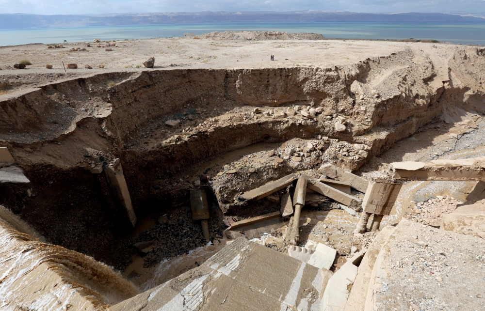 Civil defense members look for survivors after rain storms unleashed flash floods, near the Dead Sea, Jordan, on Friday. — Reuters