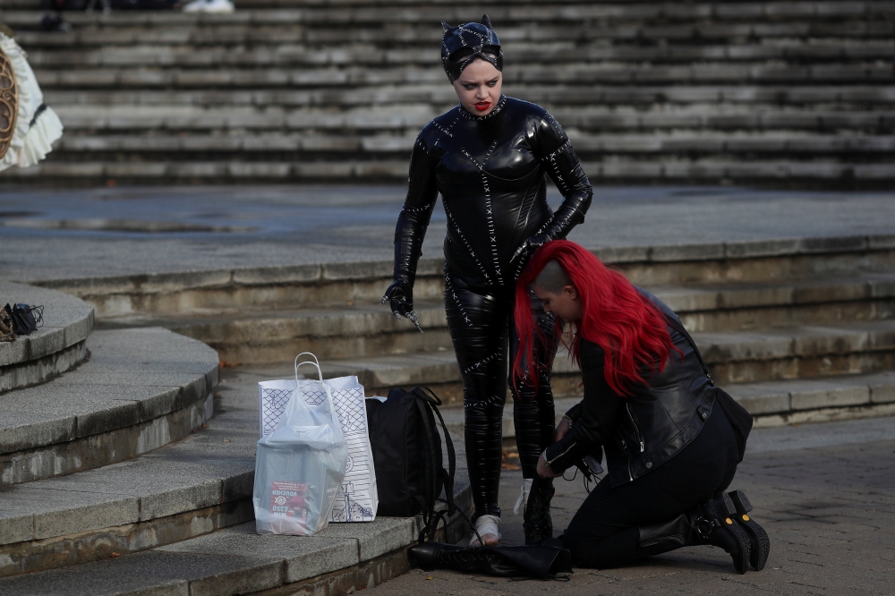 


An attendee, dressed as Catwoman for the MCM London Comic Con, is helped to put her shoes on outside the Excel Centre in London. — Reuters