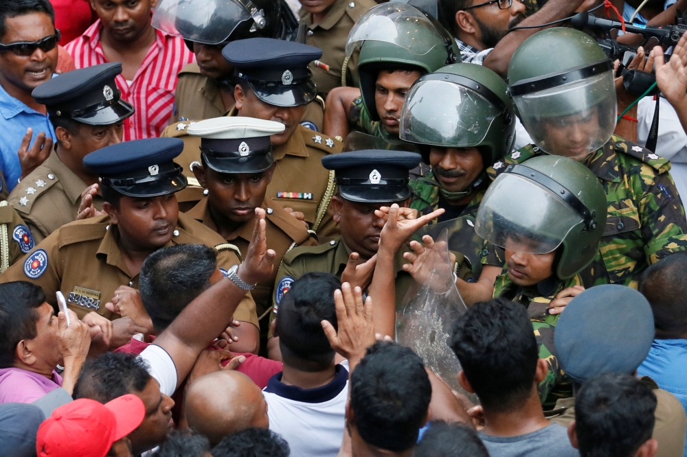 Supporters of Sri Lanka’s newly appointed Prime Minister Mahinda Rajapaksa argue with members of the Special Task Force and the police after an official security guard of sacked minister Arjuna Ranatunga shot and wounded three people in front of the Ceylon Petroleum Corporation, in Colombo, Sri Lanka, on Sunday. — Reuters