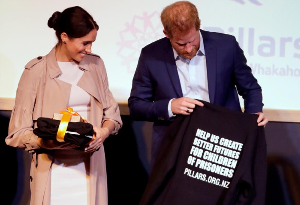 Britain’s Prince Harry and Meghan, Duchess of Sussex react to gifts they received during a visit to Pillars, a charity operating across New Zealand that supports children who have a parent in prison by providing special mentoring schemes in Auckland, New Zealand, Tuesday. — Reuters