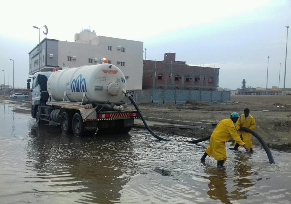 Municipality workers draining water from the street.