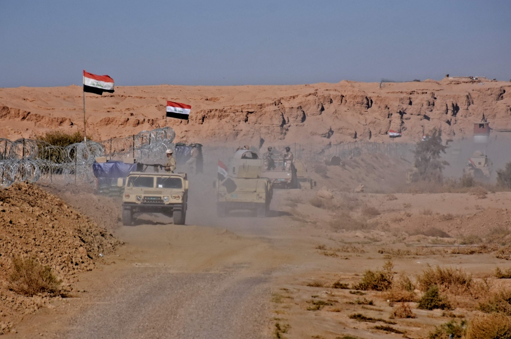 Iraqi forces gather near the Al-Qaim border crossing between Syria and Iraq on Thursday. — AFP