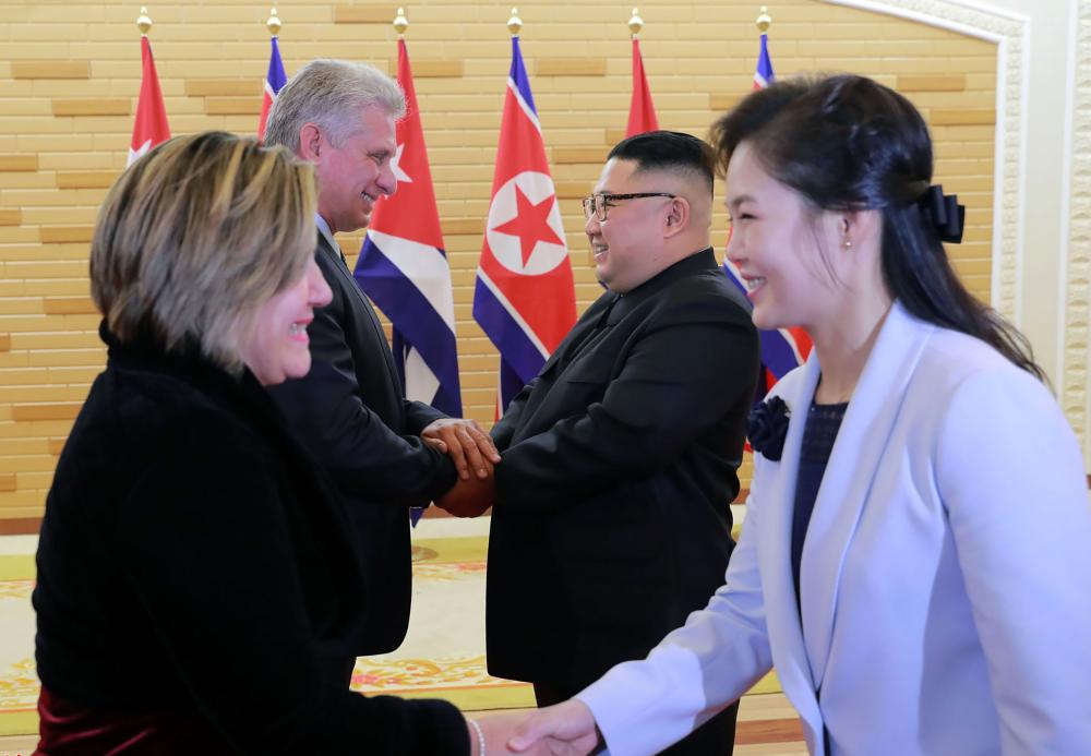 North Korean leader Kim Jong Un, second right, welcomes Cuba’s President Miguel Diaz-Canel, second left, as their wives Ri Sol Ju, right, and Lis Cuesta Peraza, left, shake hands prior to their meeting in Pyongyang on Sunday. — AFP