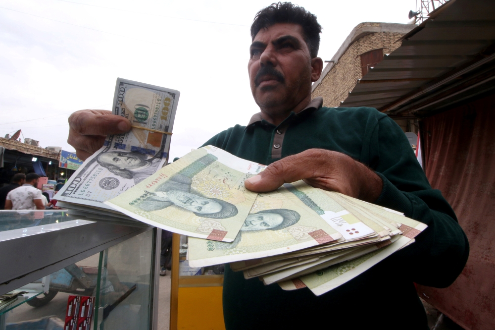 A man holds Iranian rials at a currency exchange shop before the start of the US sanctions on Tehran. — Reuters