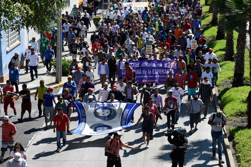 A group of Central American migrants heading in a caravan to the US, and who are staying at a shelter set up at the Sports City in the Mexican capital, during a stop in their journey, march towards the United Nations High Commissioner for Refugees (UNHCR) headquarters in Mexico City on Thursday. — AFP