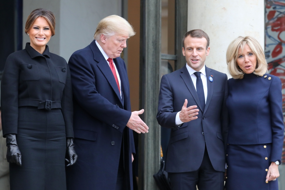US President Donald Trump (2L) stretches his hand out to shake hands with French President Emmanuel Macron (2R) next to US First Lady Melania Trump (L) and French President's wife Brigitte Macron at the Elysee Palace in Paris on Saturday following bilateral talks on the sidelines of commemorations marking the 100th anniversary of the 11 November 1918 armistice, ending World War I.  — AFP