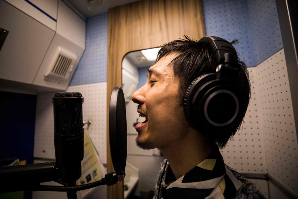 In this photo taken on Sept. 26, 2018, 33-year-old Japanese man Masaki Kitakoga sings alone in a tiny booth at a karaoke parlor in Tokyo. Kitakoga is part of a growing trend in Japan favoring solo activities that is now so widespread it has its own name: 