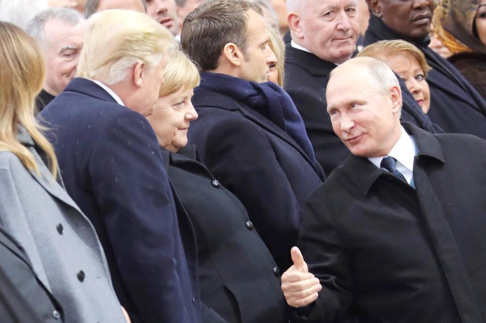


Russian President Vladimir Putin, right, talks with German Chancellor Angela Merkel, center, and US President Donald Trump as they attend a ceremony at the Arc de Triomphe in Paris on Sunday. — AFP