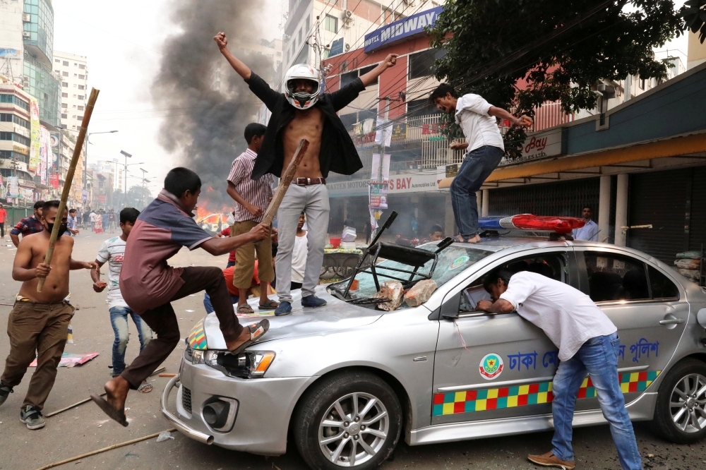Bangladesh Nationalist Party activists vandalize a police vehicle during clashes in Dhaka on Wednesday. — Reuters