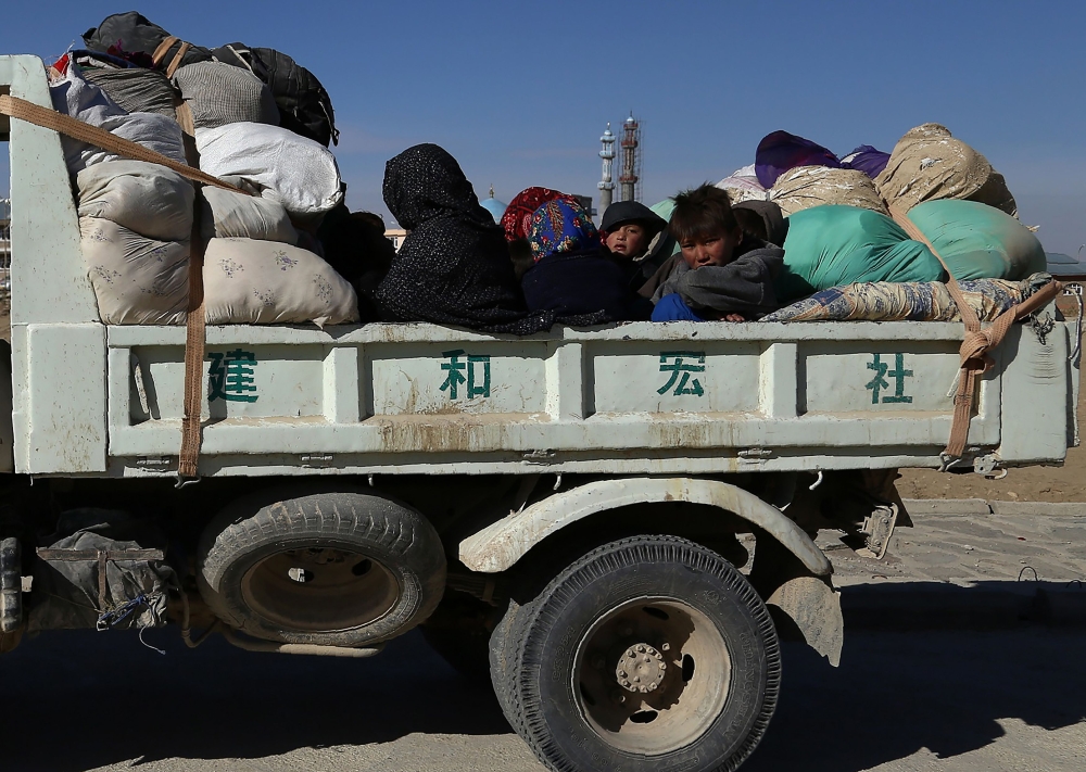Members of an internally displaced Afghan family sit on a truck as they flee from Jaghori district to escape ongoing battles between Taliban and Afghan security forces in Ghazni on Thursday. — AFP