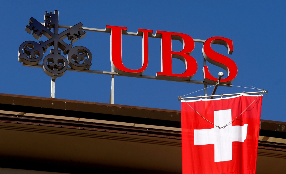 Switzerland's national flag flies under the logo of Swiss bank UBS in Zurich, Switzerland, in this file photo. — Reuters