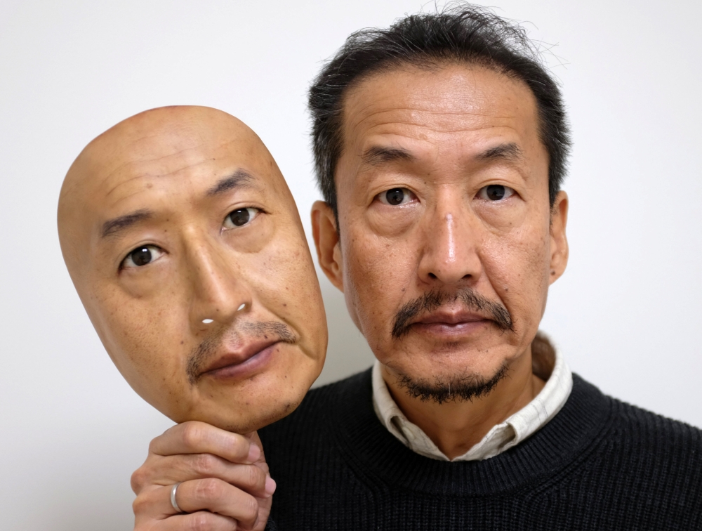REAL-f Co. President Osamu Kitagawa shows off a super-realistic face mask at his factory in Otsu, western Japan. — Reuters