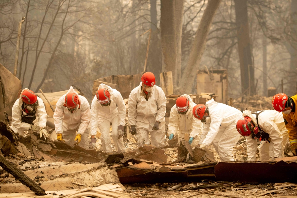 Rescue workers sift through rubble in search of human remains at a burned property in Paradise, California, on Wednesday. — AFP