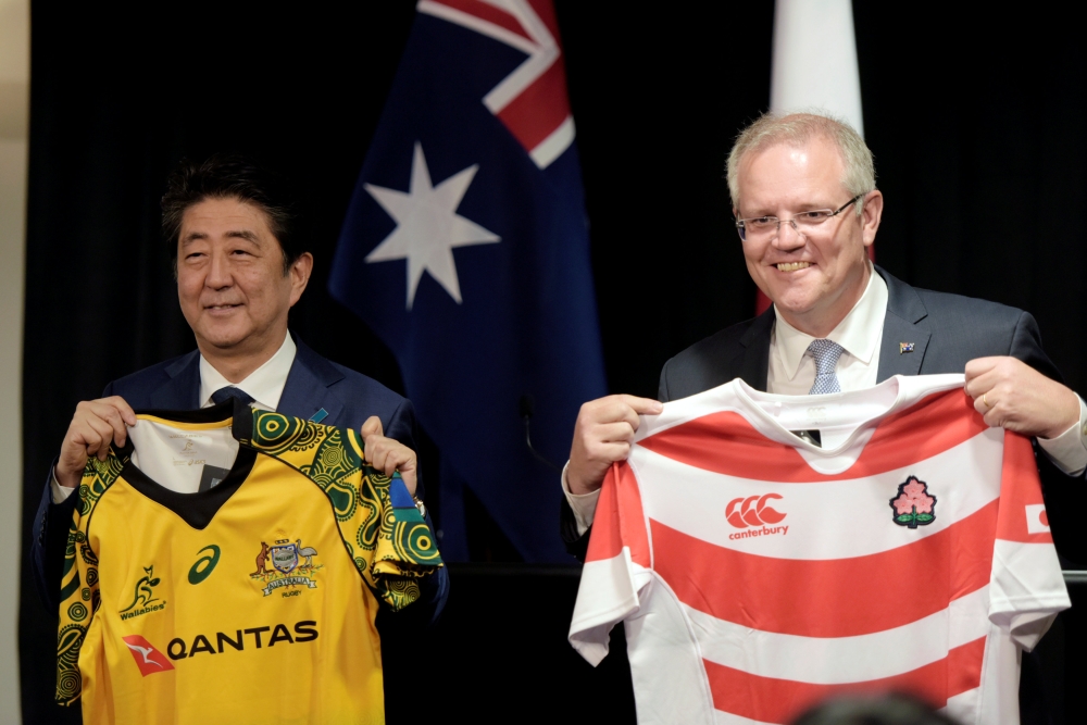 Japanese Prime Minister Shinzo Abe and Australian Prime Minister Scott Morrison hold up rugby jerseys after bilateral talks at Northern Territory Parliament House in Darwin, Northern Territory, Australia, on Friday. — Reuters