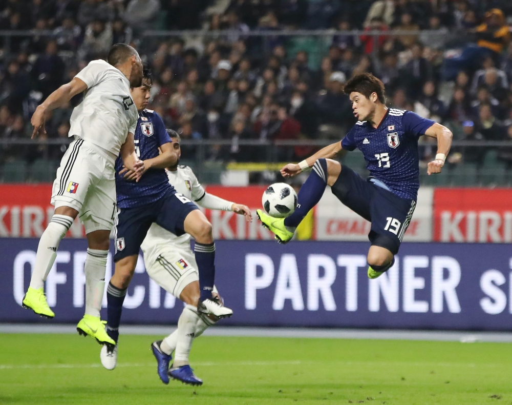 Japan's defender Hiroki Sakai (R) shoots to score a goal during the friendly football match between Japan and Venezuela in Oita on Friday. — AFP