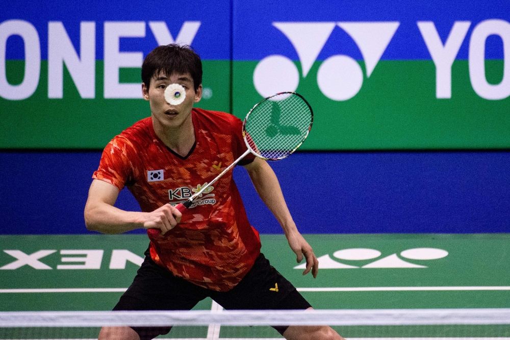 South Korea's Son Wan-ho hits a return against Kento Momota of Japan in their men's singles semifinal match at the Hong Kong Open badminton tournament on Saturday. — AFP