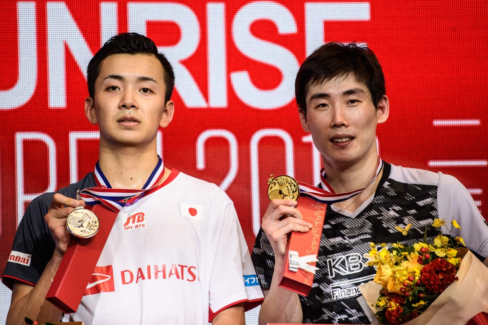 South Korea's Son Wan-ho (R) celebrates winning the men's singles final against Japan's Kenta Nishimoto (L) at the Hong Kong Open badminton tournament on Sunday. — AFP