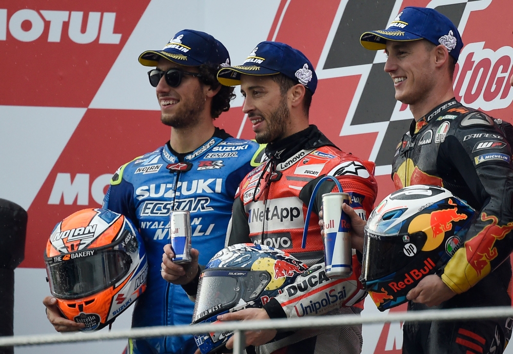 Race winner Ducati Team's Italian rider Andrea Dovizioso (C) celebrates on the podium with second placed Team Suzuki Ecstar's Spanish rider Alex Rins (L) and third placed Red Bull KTM Factory Racing's Spanish rider Pol Espargaro after the MotoGP race of the Valencia Grand Prix at the Ricardo Tormo racetrack in Cheste, on Sunday. — AFP