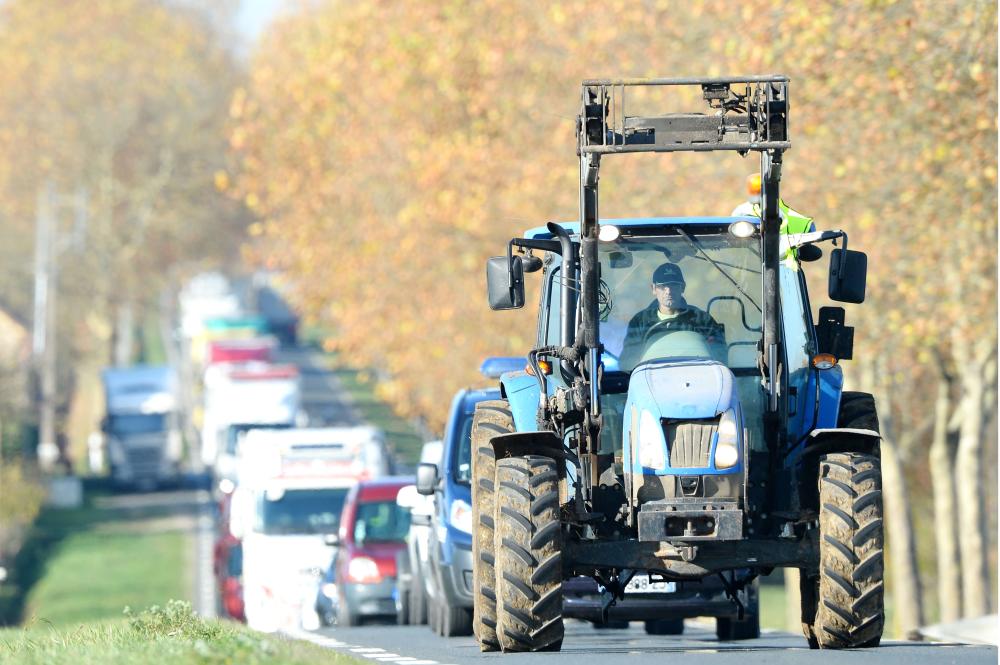 


A tractor drives with yellow vest (gilet jaune) as a dozen farmers take part in an operation to slow the traffic, between Saint Calais and Epuisay, on the D157 or Orleans-Blois road on Monday on the third day of nationwide protest against high fuel prices. — AFP