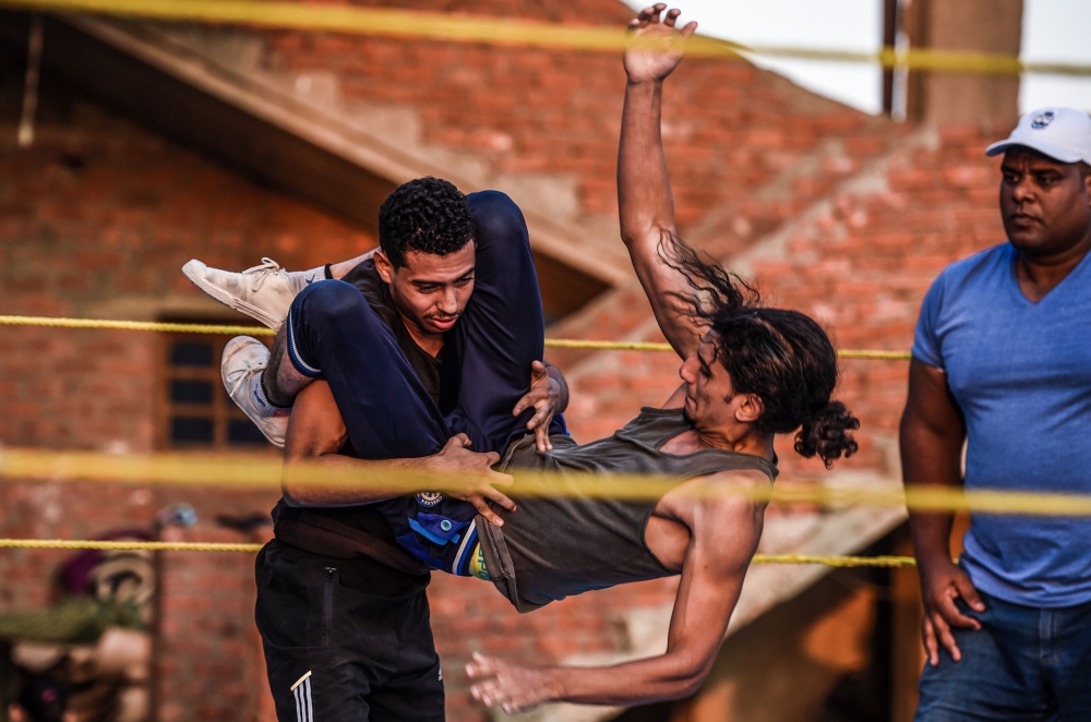 Members of the self-declared Egyptian Wrestling Federation (EWR) train in a ring during a session outside the federation founder's home in the village of Serapeum in the Suez canal province of Ismailia. — AFP